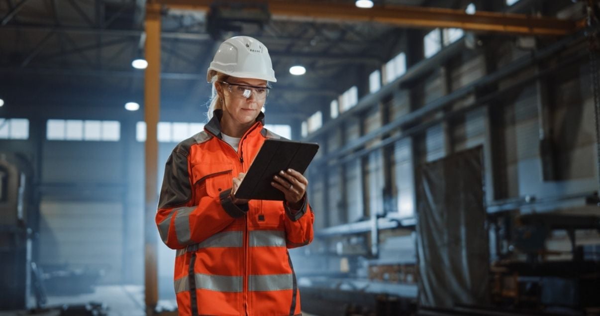 Female engineer supervising PPE usage with mobile forms