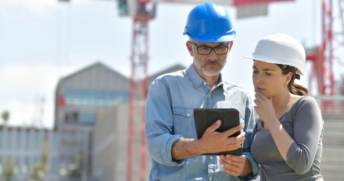 Male and female workers looking at a mobile form