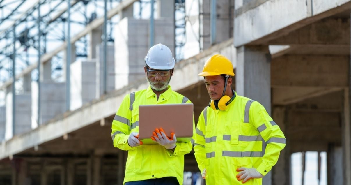 Male construction workers filling out a mobile form on site