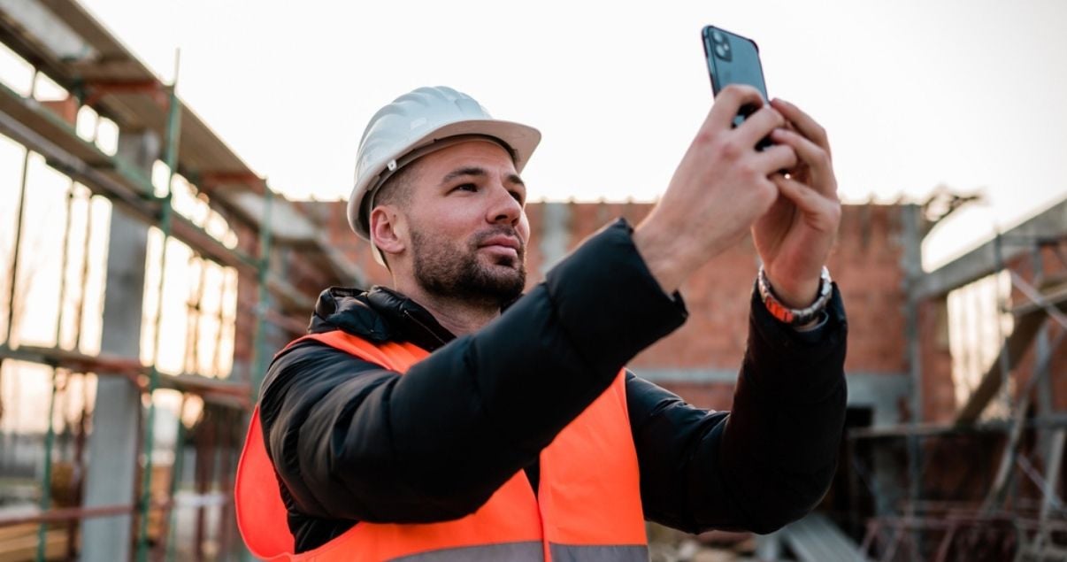 Building inspectior using his mobile device to take pictures of the building being inspected