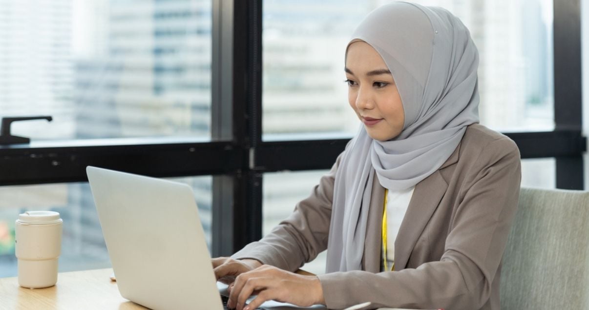 Female worker using mobile forms on her computer