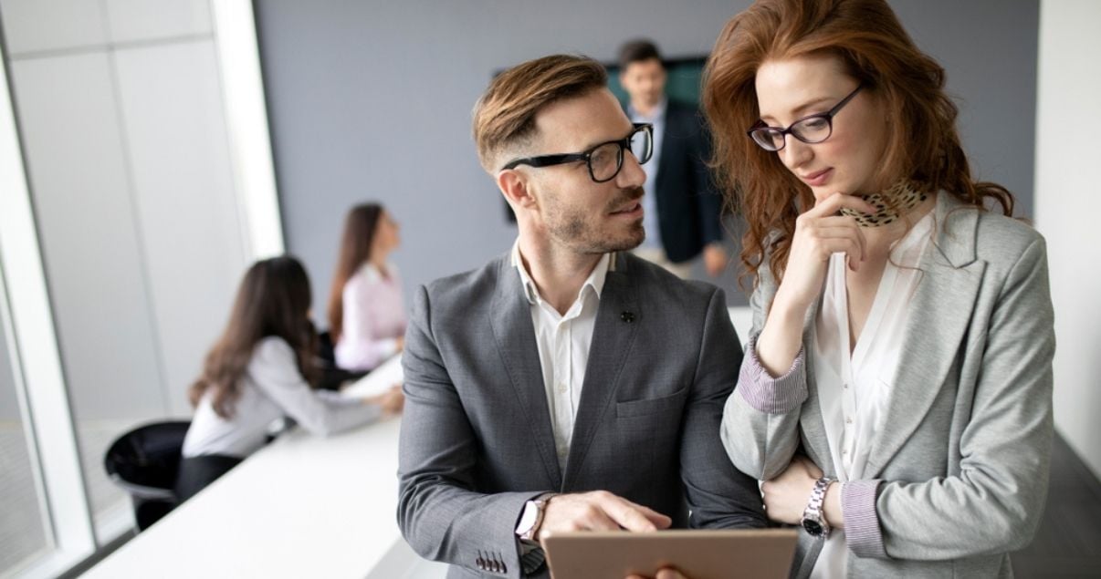 Male and femal coworkers discussing information collected through mobile forms