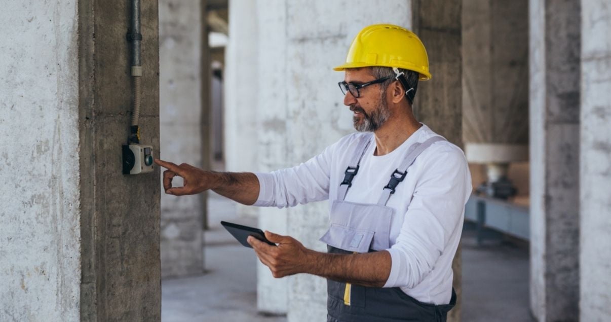 Middle aged man collecting information regarding a building inspection through mobile forms