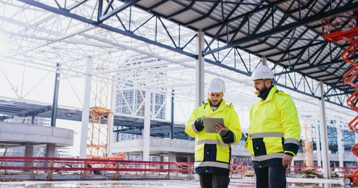 Two male engineers collecting data on their mobile device