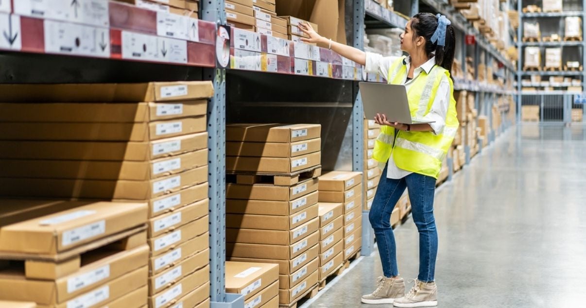 Female worker using checklists to assess inventory at a storage warehouse