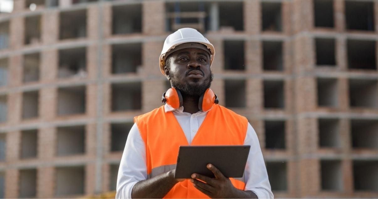 Male construction worker completing checklists on the field