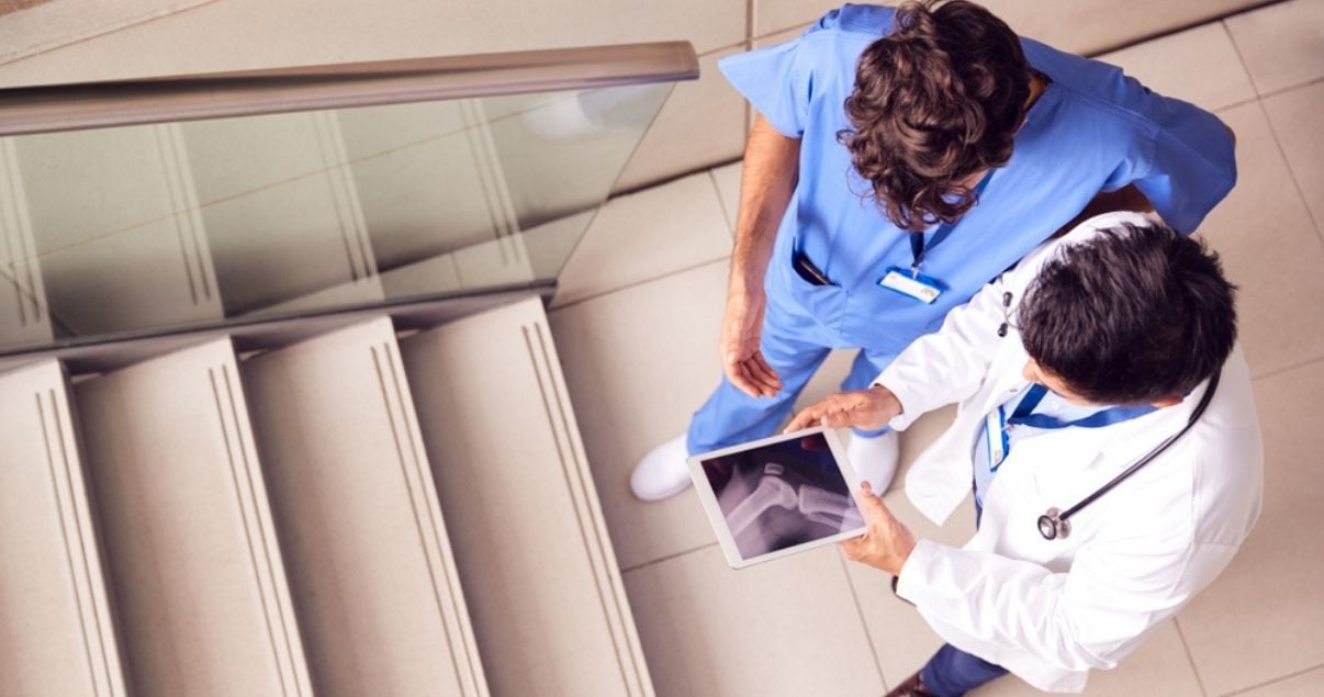 Male doctor colleagues reviewing an image collected using mobile forms