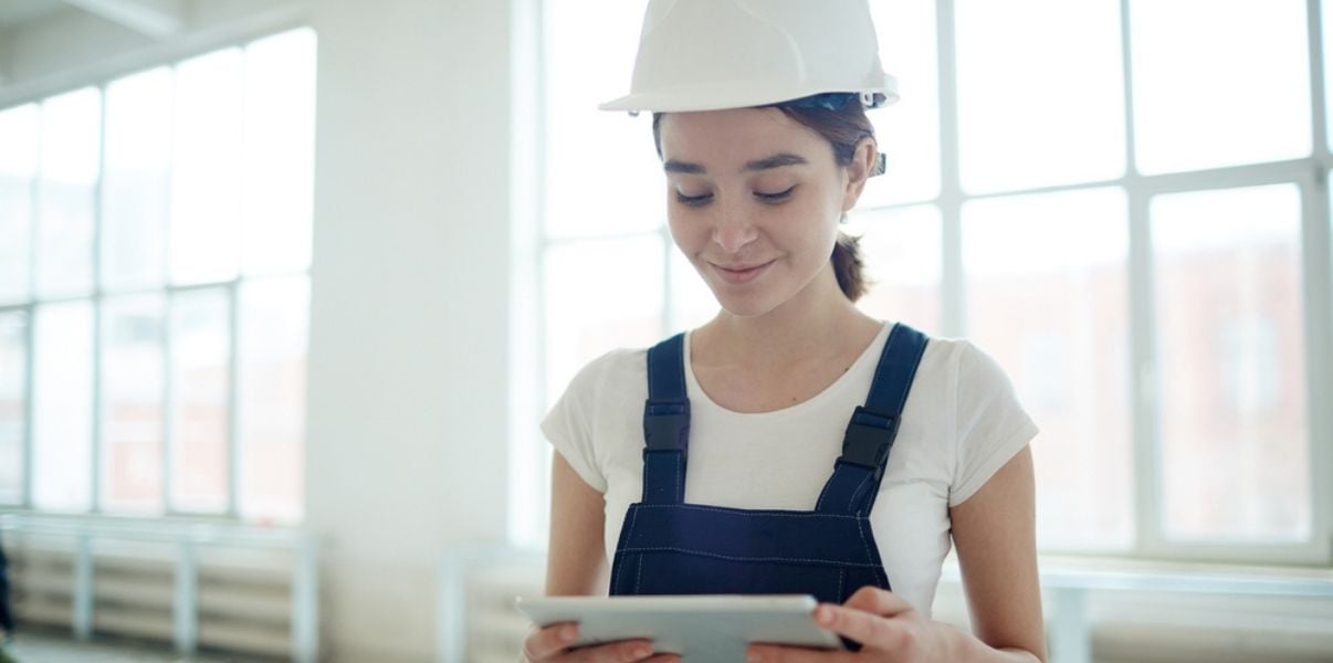 Young brunette female inspector performing a site inspection using mobile forms